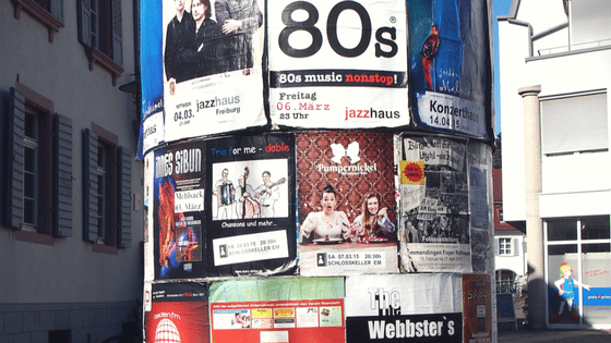 image of a pole completely cluttered by promotional flyers